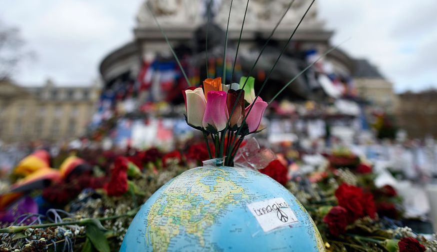 topshot   this picture taken on december 24, 2015 shows a globe and roses on a makeshift memorial at place de la republique in paris on december 24, 2015 to pay tribute to the victims of the november 13 terror attacks
a coordinated series of gun and bomb attacks at several sites in paris on november 13 left 130 dead  afp  miguel medina        photo credit should read miguel medinaafp via getty images