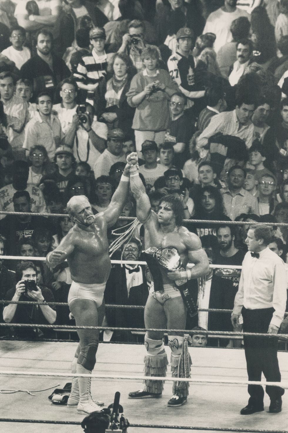 Hulk Hogan hoists the hand Ultimate Warrior