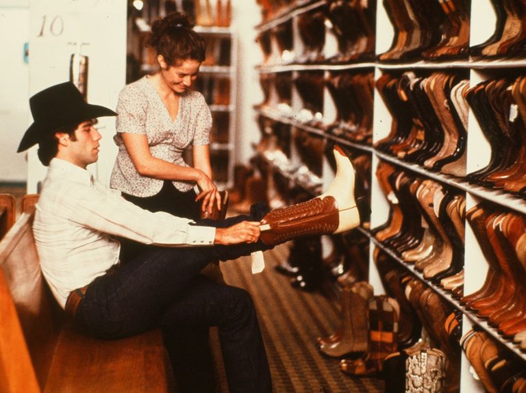 circa 1980 actor john travolta tries on cowboys boots in a scene during the paramount pictures movie  urban cowboy circa 1980 photo by hulton archivegetty images