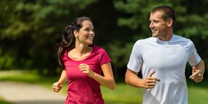 portrait of cheerful caucasian couple running outdoors