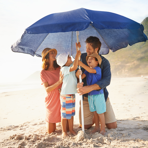 family putting up beach umbrella