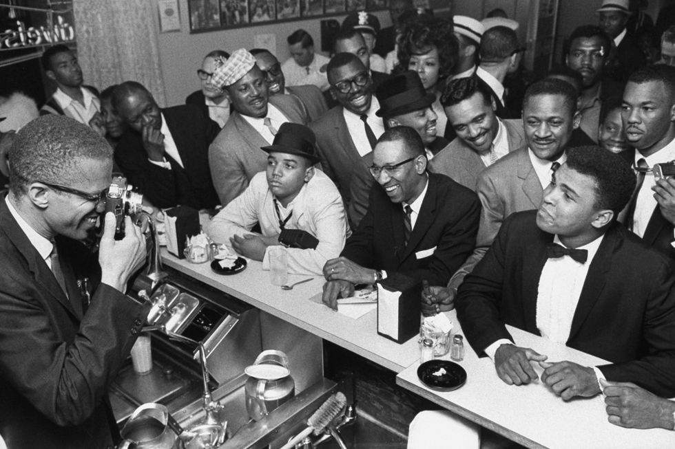march 1964   miami black muslim leader malcolm x l behind soda fountain training his camera on tux clad cassius clay now muhammad ali r sitting at counter surrounded by jubilant fans after he beat sonny liston for the heavyweight championship of the world  photo by bob gomelthe life images collection via getty imagesgetty images