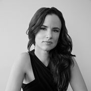 a black and white portrait of juliette lewis with her hair down wearing a black wrap neck dress