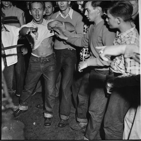 raging, cursing mob member w others, raising his shirt to show a wound he says was inflicted by a national guardsmans bayonet during race riot at the apartment of african amer harvey clark whom they had driven out of town  photo by wallace kirklandthe life picture collection via getty images