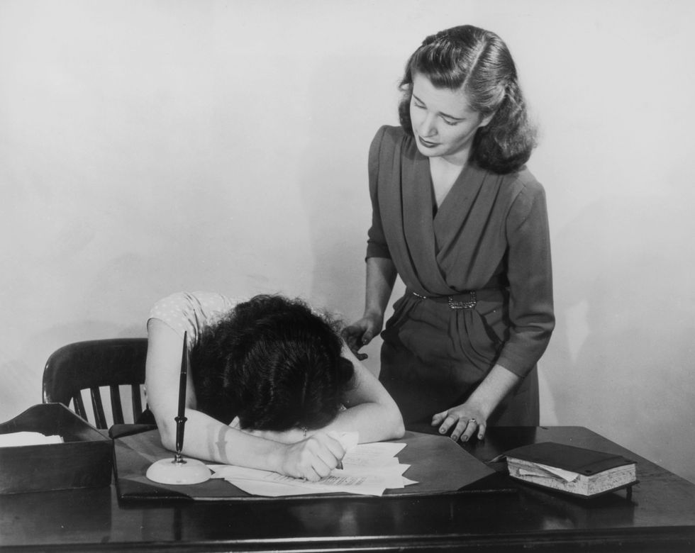 a woman moves to comfort a co worker who is slumped over her desk in despair, circa 1940 photo by fpghulton archivegetty images