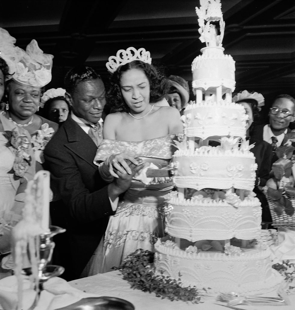 american jazz singers nat king cole 1917 1965 and maria hawkins ellington each hold a hand on a knife as they cut their wedding cake at a reception following their marriage at the abyssianian baptist church, harlem, new york, march 28, 1948 at left is coles mother, perlina adams coles photo by lisa larsenthe life images collection via getty imagesgetty images