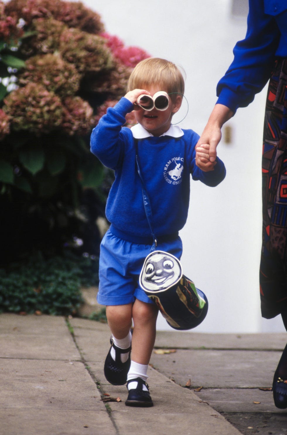 prince harry looks at photographers as he leaves on his first day at mrs mynors nursery school