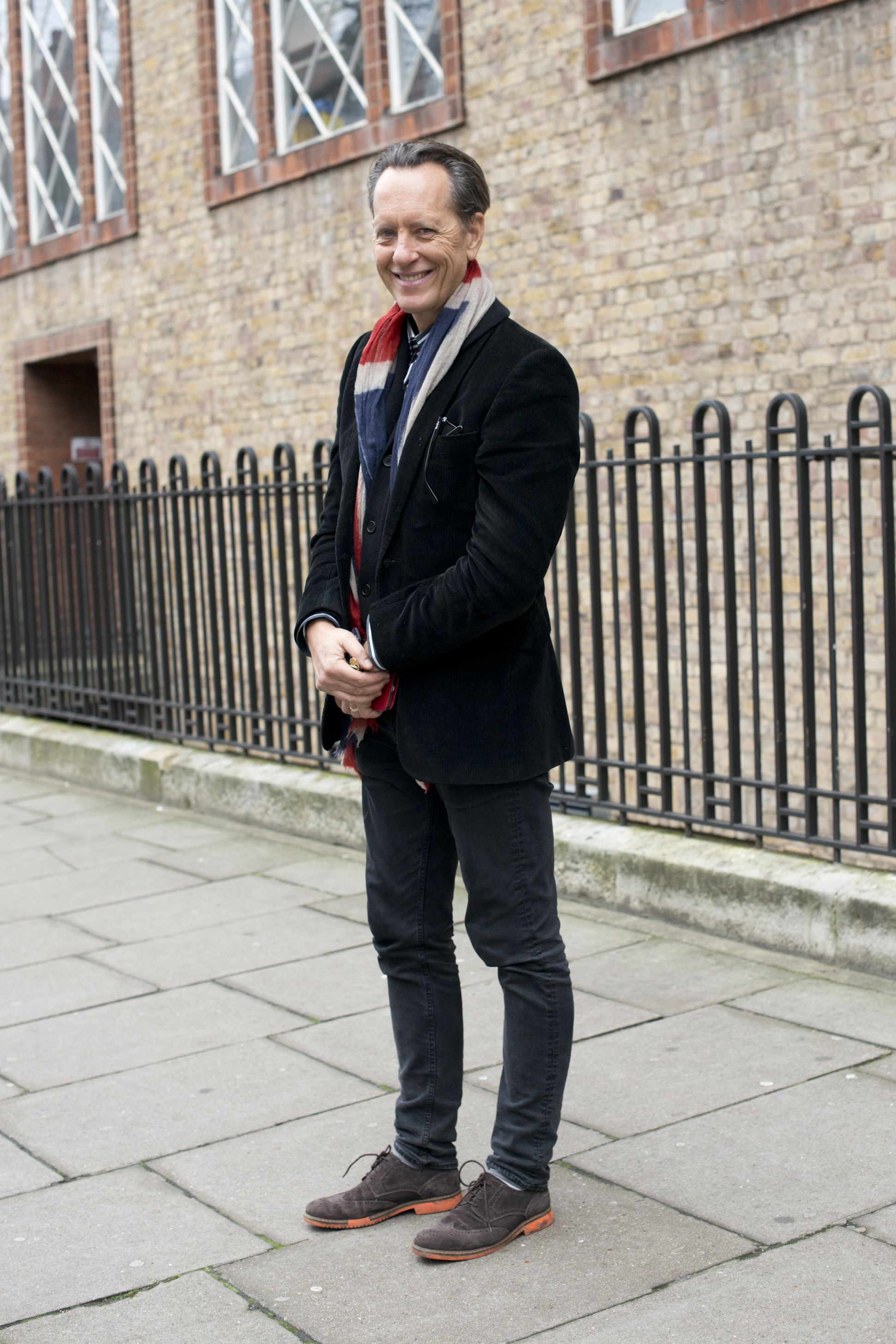 Hipster man wearing black style leather outfit with hat, pants, jacket and  shoes standing on city street Photos