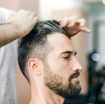 bearded man receiving haircut in the barbershop