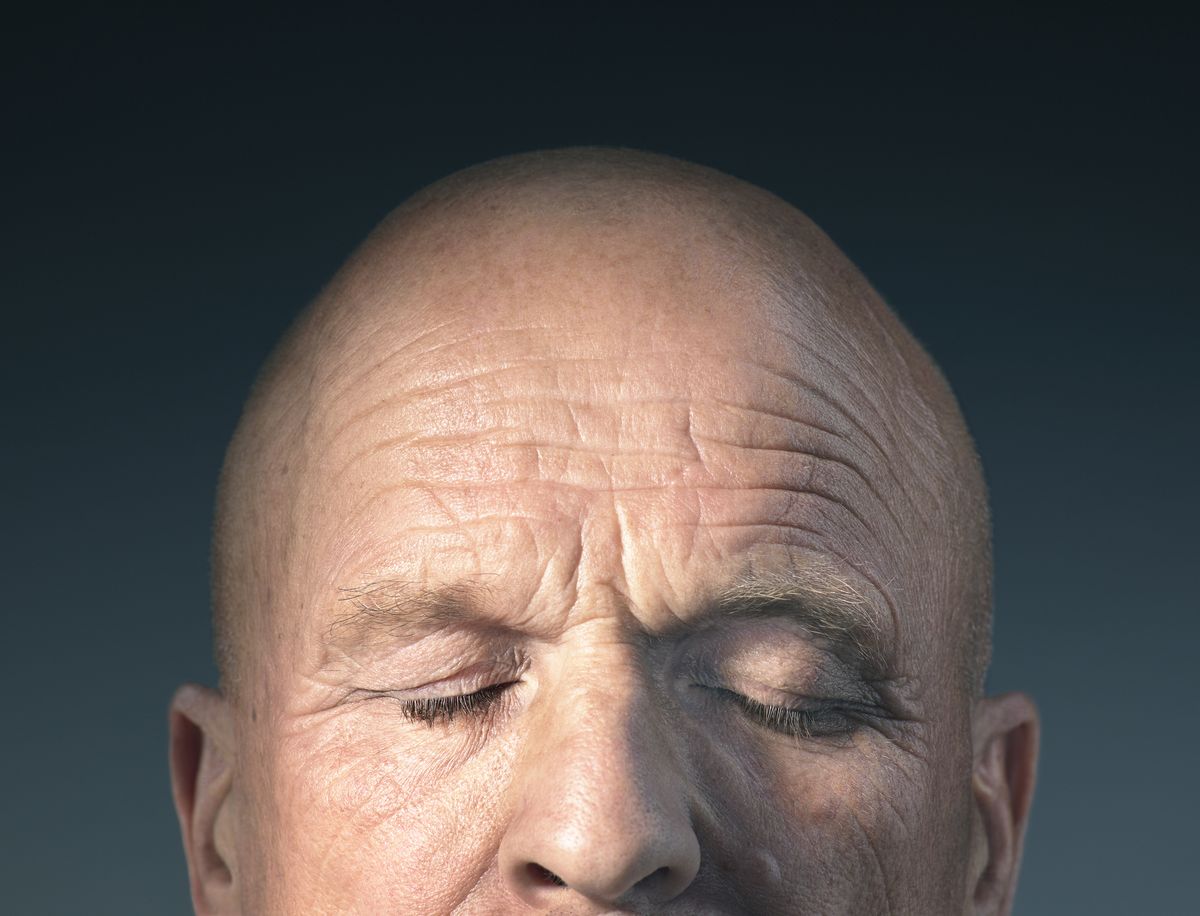 studio photograph of middle aged mans head with eyes closed