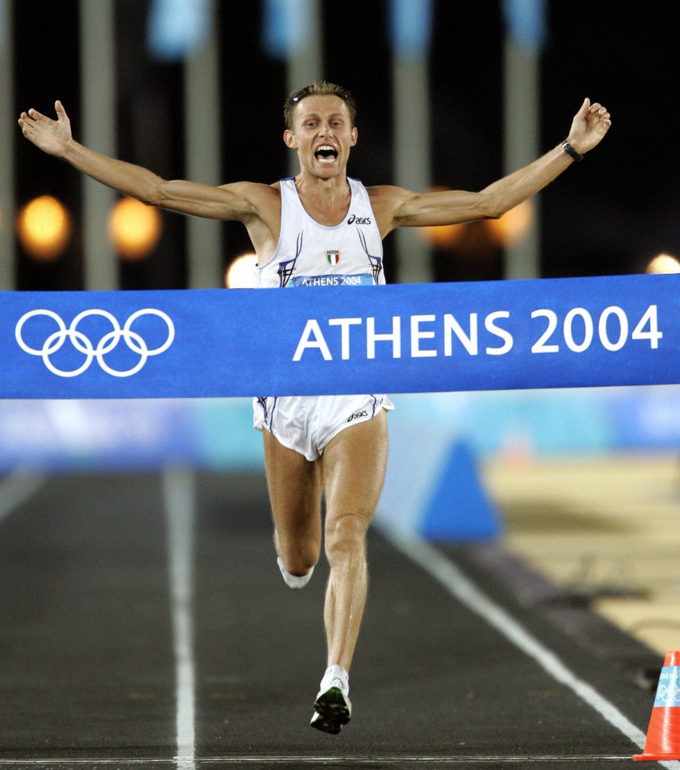 athens, greece mens marathon winner stefano baldini of italy crosses the finish line as he arrives in the panathinaiko stadium in athens 29 august 2004 the mens marathon is the final event of the athens olympic games baldini crossed the line in 2hr 10min 55sec, mebrahtom keflezighi of the united states took the silver medal and de lima recovered and hung on to win the bronze medal afp photo timothy clary photo credit should read timothy claryafp via getty images