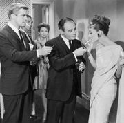 1961, american actors george peppard and martin balsam compete to light belgian born actor audrey hepburns cigarette at a formal party in a still from director blake edwards film, breakfast at tiffanys photo by paramount picturesgetty images
