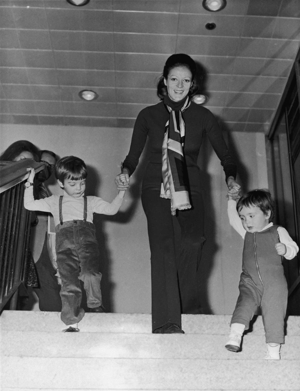 english actress maggie smith with her two children, chris larkin left and toby stephens, at london airport, march 1971