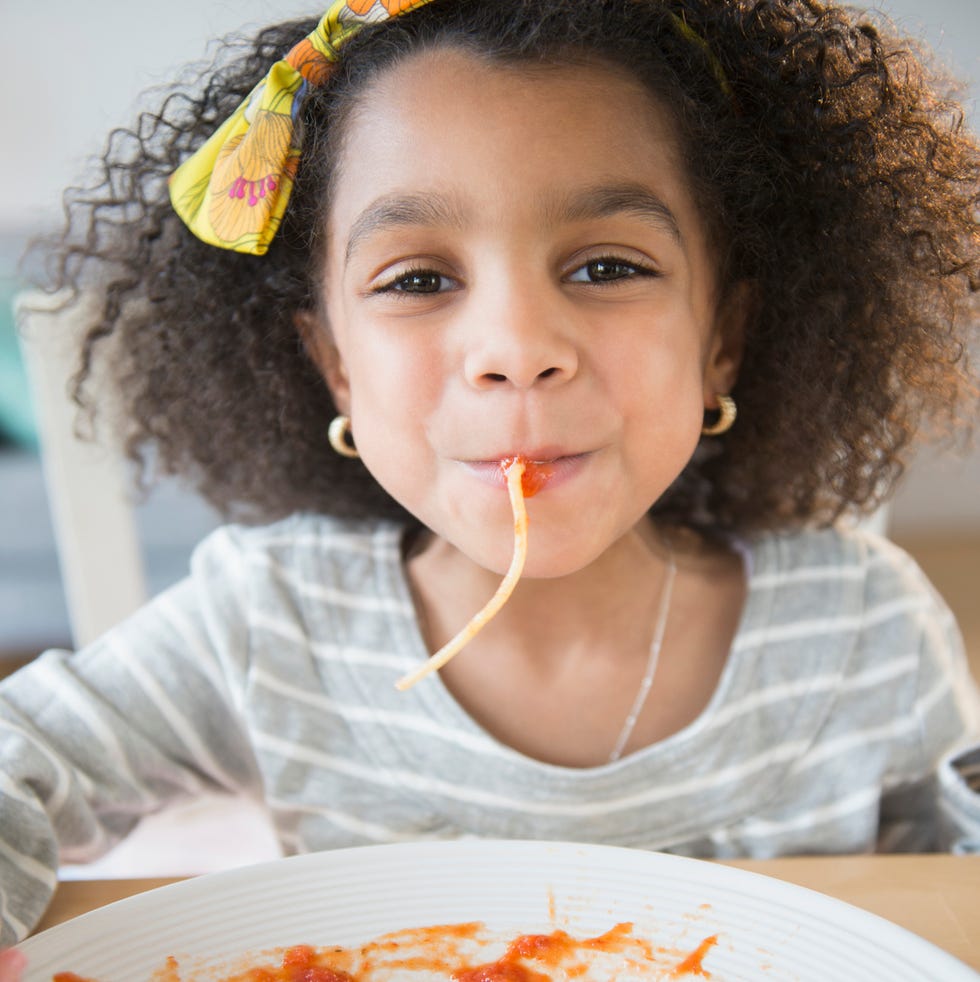 january holidays little girl eating spaghetti from a plate