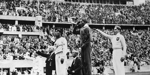 the gold, silver and bronze medal winners in the long jump competition salute from the victory stand at the 1936 summer olympics in berlin from left, japans naoto tajima bronze, american jesse owens gold who set an olympic record in the event and offers an american style salute with his hand to his forehead, and germanys luz long silver giving a nazi salute with his arm extended out august 8, 1936