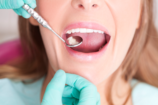 woman having teeth examined by dentist