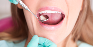 woman having teeth examined by dentist