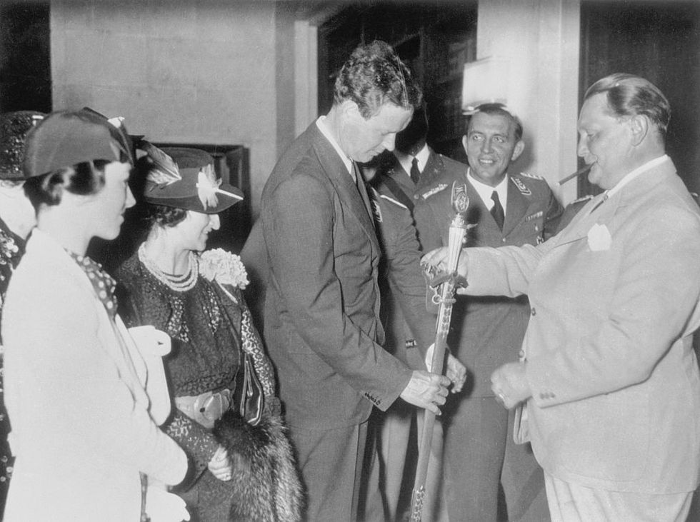 herman goering, one of germanys most powerful men is displaying a ceremonial sword to the lindberghs