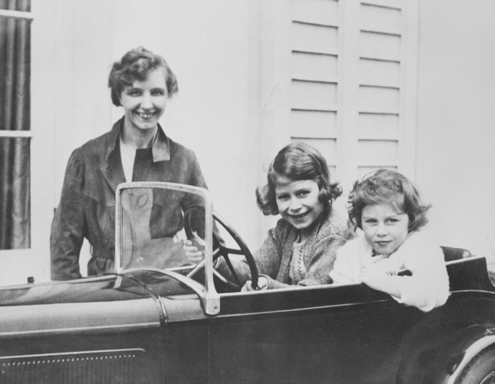 princess elizabeth c and her younger sister princess margaret of great britain play in a miniature automobile while their governess, marion crawford, keeps an eye on them elizabeth will grow up to become queen elizabeth ii