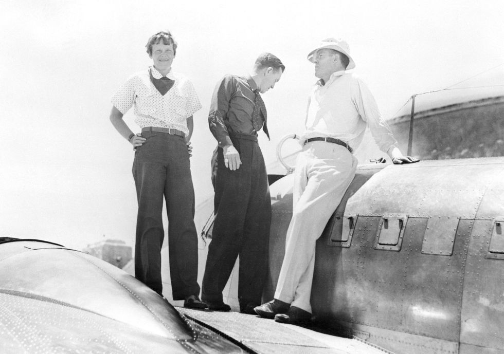 Links Na een testvlucht in Miami voor haar tweede poging om rond de wereld te vliegen poseert Earhart op de vleugel van haar Lockheed Electra 10E met navigator Fred Noonan midden en echtgenoot George Palmer Putnam