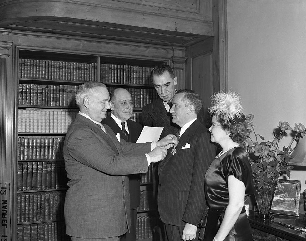 gen william j donovan, wartime oss chief, presents medal for merit to canadian born sir william s stephenson, who was director of british security coordination in the western hemisphere from 1940 45 looking on during ceremony in sir williams suite at the dorset hotel are left to right col edward g buxton, assistance director of oss robert sherwood, noted playwright, and lady stephenson