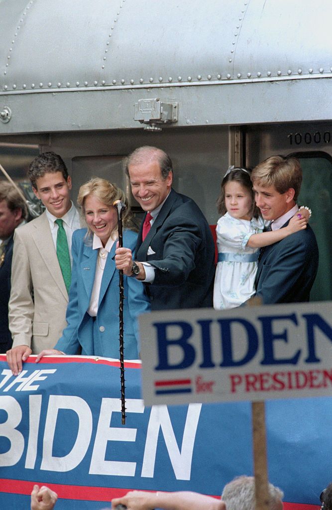 original caption wilmington, delaware sen joseph biden of delaware smiles as he grabs a walking stick presented him for the campaign by a supporter as he leaves aboard a train for washington after announcing for president here 69 looking on are wife, jill, daughter ashley and sons beau and hunt