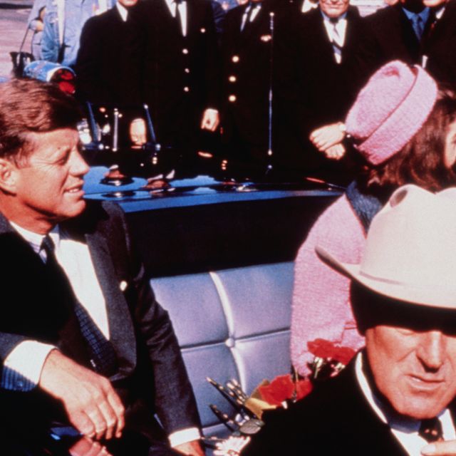 (Original Caption) Texas Governor John Connally adjusts his tie (foreground) as President and Mrs. Kennedy, in a pink outfit, settled in rear seats, prepared for motorcade into city from airport, Nov. 22. After a few speaking stops, the President was assassinated in the same car.