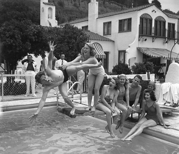 vintage birthday photos (original caption) 6/11/1939 santa monica, ca mickey rooney goes off the diving board, as marjorie gestring gives him a push, during judy garlands birthday party at louis b. mayers santa monica beach home. judy garland, june preisser, jackie cooper, and virginia weidler sit (l to r) behind them on the board. on the edge of the pool is ann rutherford.