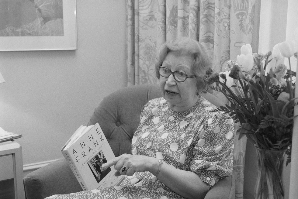 original caption new york holding a copy of her book, anne frank remembered, miep gies, who helped hide the frank family from the nazis, talks to reporter here gies found the notebooks that formed anne frank's diary but waited for years before she read what anne had written