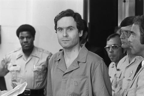 a man looks forward as he stands amid a group of police officers