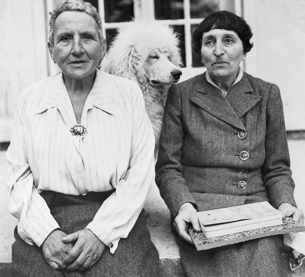 Gertrude Stein and Alice B. Toklas with their dog Basket in front of her home in France