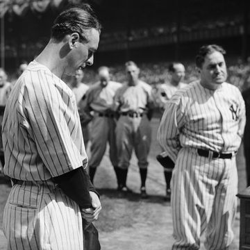 Iron man Lou Gehrig, first baseman for the Yankees, whom sickness benched, stands with his head bowed as tears well into his eyes during the ceremonies honoring him at Yankee Stadium. Sixty thousand fans and many famous figures of baseball were present for the ceremonies.