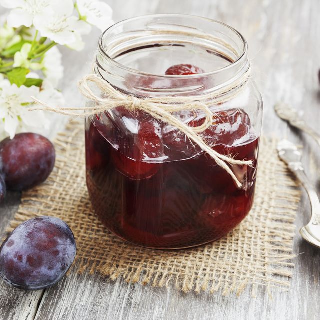 plum jam in a glass jar on the wooden table