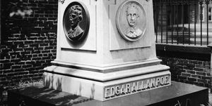 a large headstone engraved with edgar allan poe and busts of the man