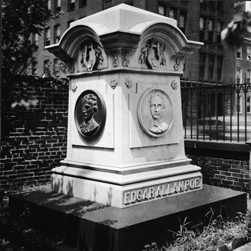 a large headstone engraved with edgar allan poe and busts of the man