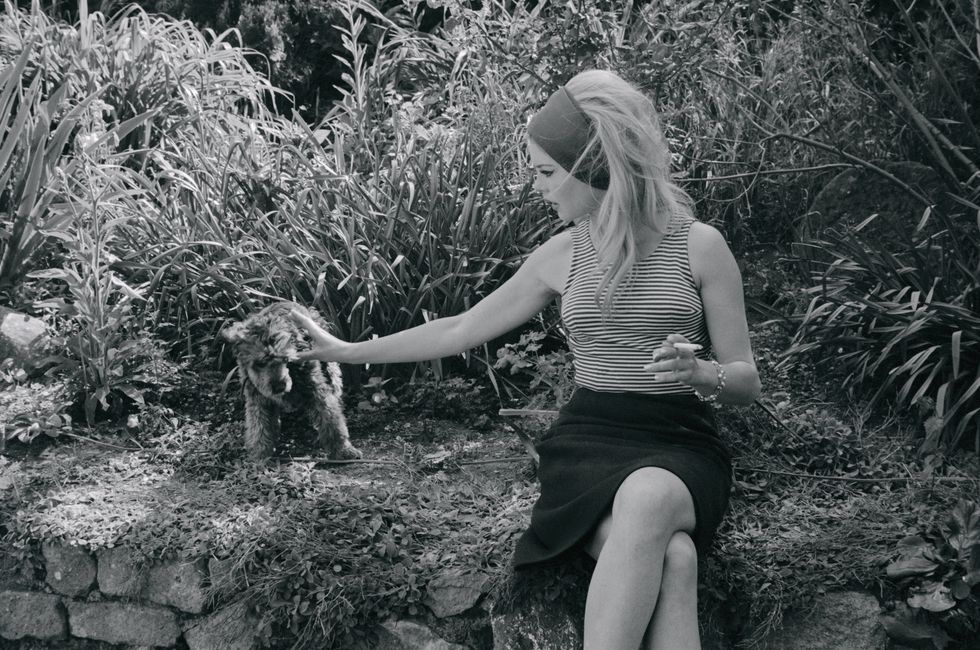 Brigitte Bardot con cinta del pelo XL acariciando un perro