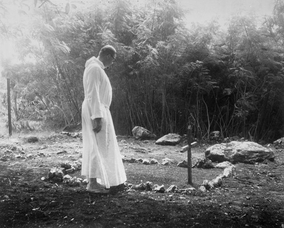 Een geestelijke bidt bij een graf op Saipan waarvan ooit werd gedacht dat hier de stoffelijke overschotten van Amelia Earhart en Fred Noonan in lagen Later werd ontdekt dat hier mensen van de lokale bevolking waren begraven