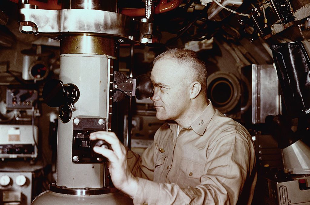 original caption captain edward l beach, usn, commanding officer of the nuclear submarine uss triton, at the periscope of his ship during her shakedown cruise around the world submerged