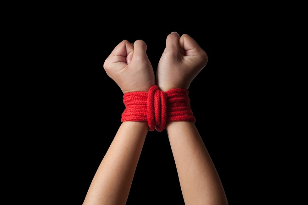 hands of a missing kidnapped, abused, hostage, victim woman tied up with rope in emotional stress and pain, afraid, restricted, trapped, call for help, struggle, terrified
