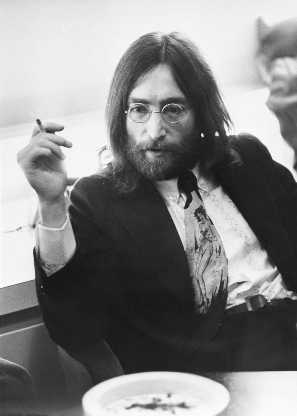 musician john lennon of the beatles relaxing with a cigarette