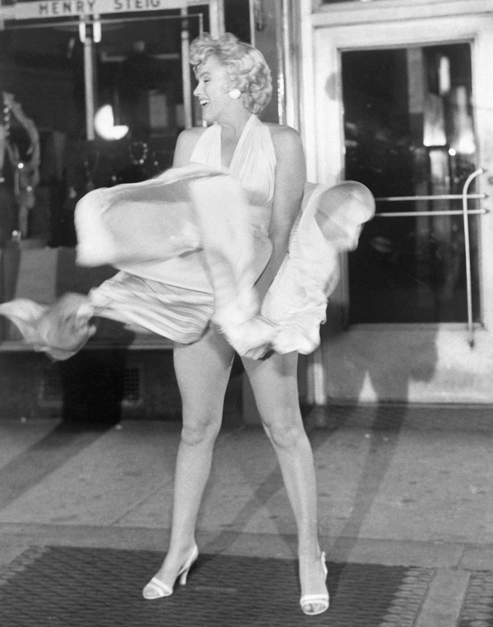 actress marilyn monroe tries to hold down her dress as wind from a subway grate blows it upward during filming of the seven year itch motion picture in manhattan