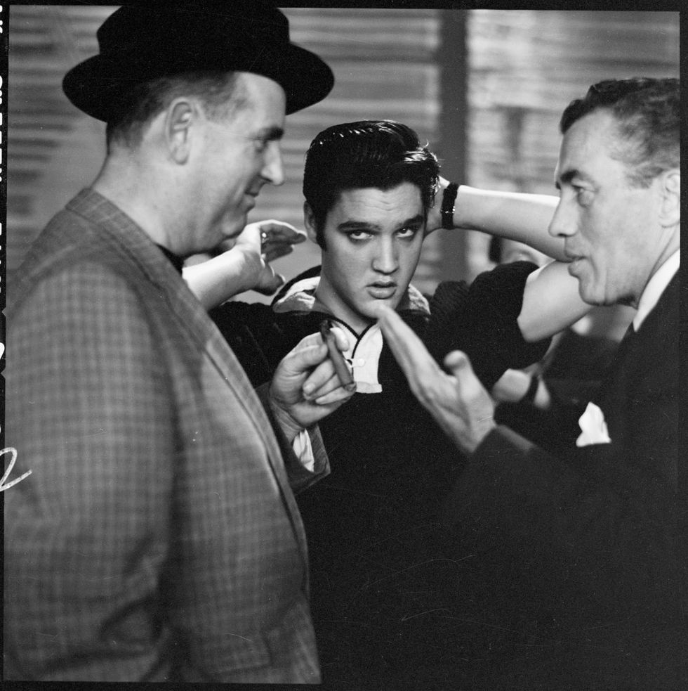 backstage before his second appearance on the ed sullivan show, american rock and roll singer and actor elvis presley 1935   1977 center adjusts his hair as sullivan 1902   1974 right  the shows host, explains something to presleys manager colonel tom parker 1909   1997, new york, new york, october 28, 1956 photo by cbs photo archivegetty images