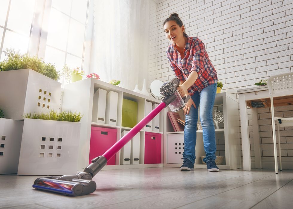 beautiful young woman makes cleaning the house woman vacuums the floor