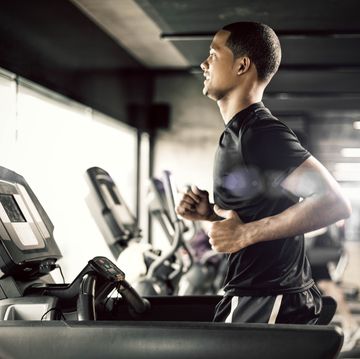 healthy young man in gym running on treadmill