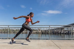 attractive ethnic female sprinter training in the city