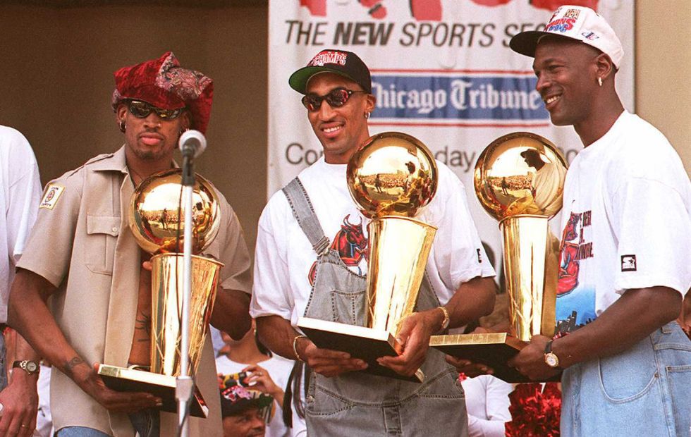 chicago, il   june 18  chicago bulls players dennis rodman l, scottie pippen c and michael jordan r hold three of the teams four recent larry obrien trophies 18 june at a rally for the team in grant park in chicago  thousands of fans crowded into the park to see the nba champions  photo credit should read tim zielenbachafp via getty images