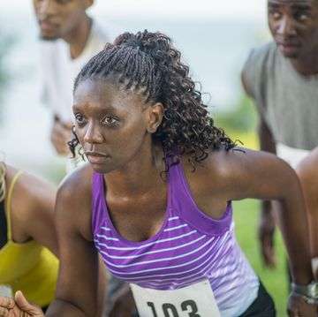 a multi ethnic group of young adults are at the starting line of a running race they are focused and determined