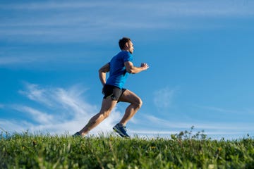 young man running outdoor he is wearing a blue t shirt and black shorts healthy lifestyle concept