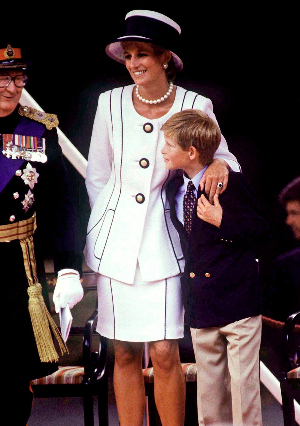 princess diana cuddles prince harry during the vj day celebrations