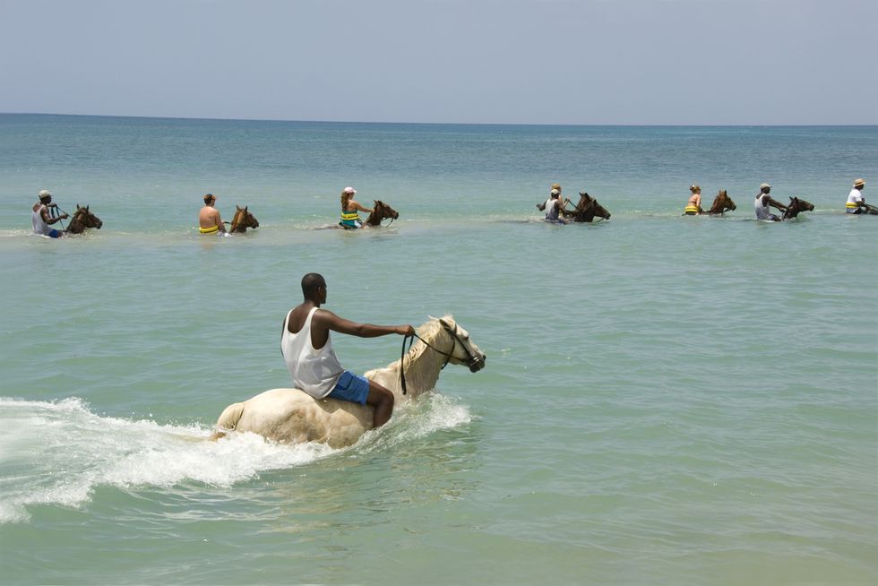 a person riding a horse in the ocean